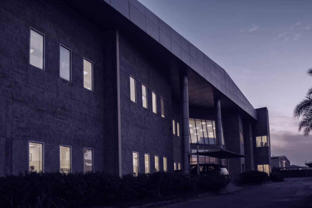 Modern corporate office building at dusk with illuminated interior windows showcasing advanced data center infrastructure.
