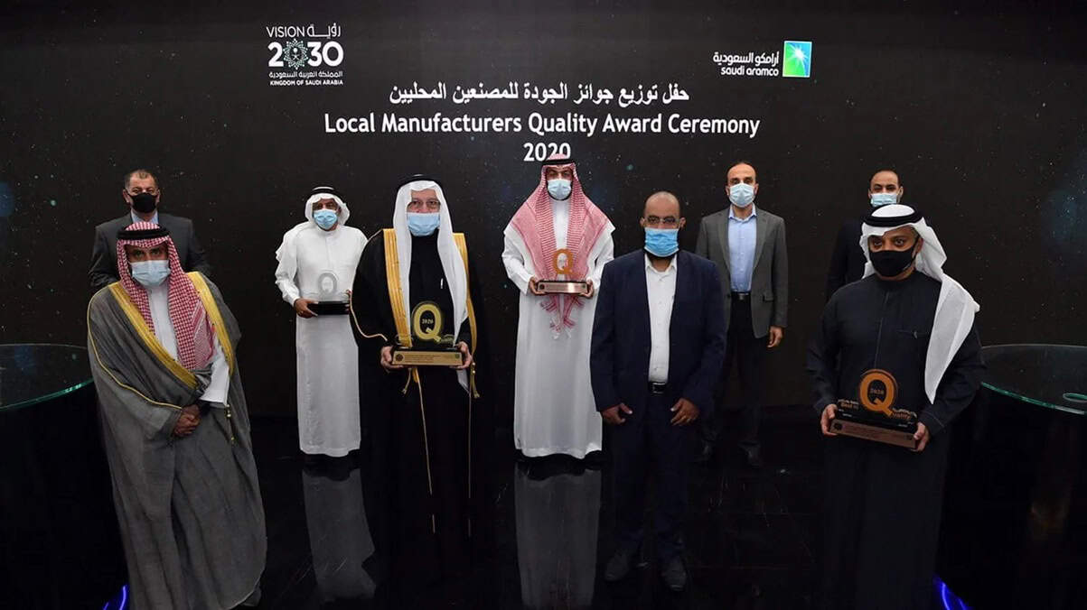 Group photo of award recipients at the Local Manufacturers Quality Award Ceremony 2020, with diverse officials and winners in traditional and business attire.